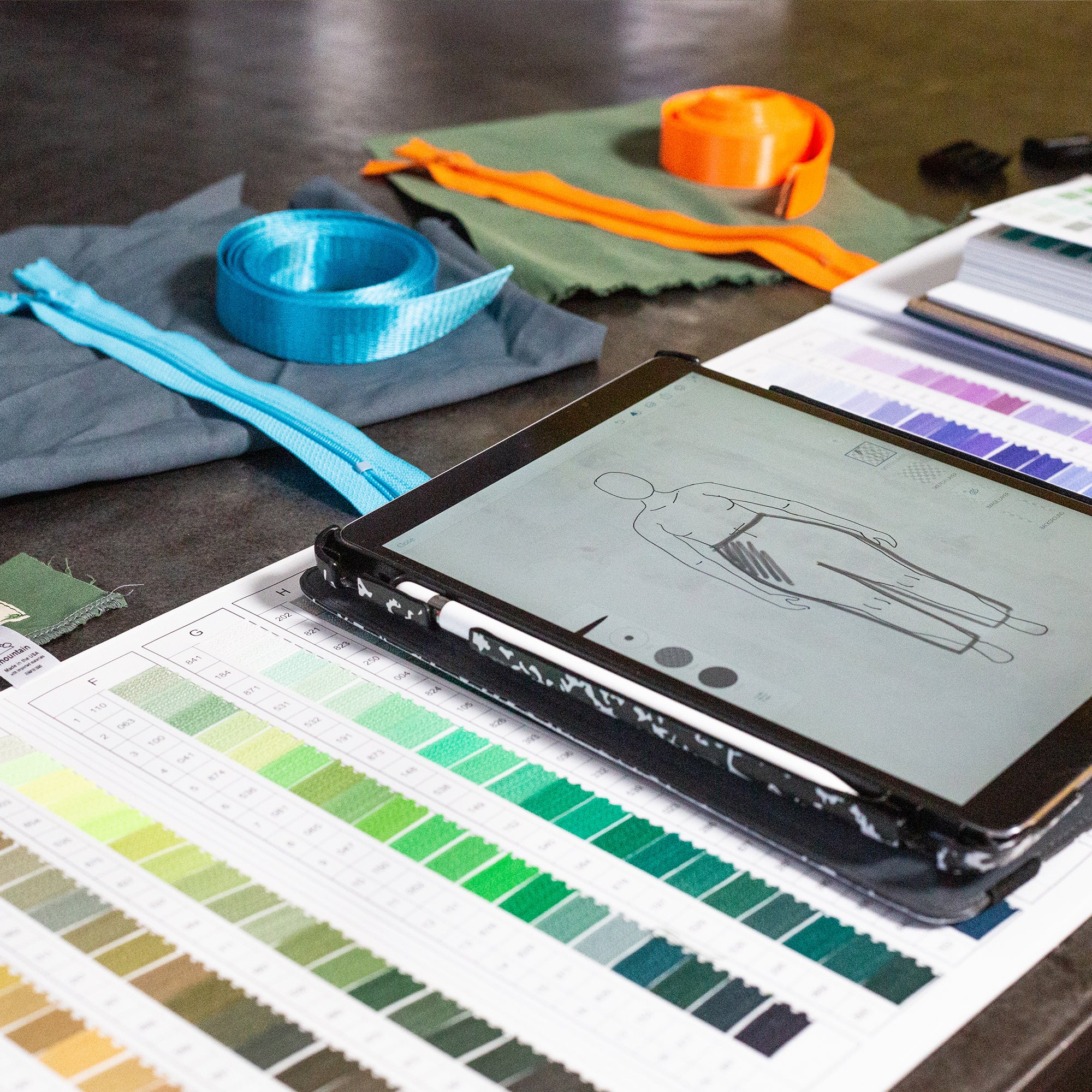 apparel design process on ipad with color swatches and fabric.